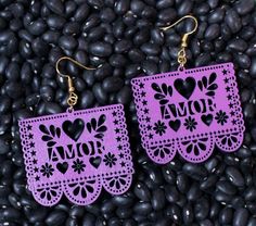 two pairs of earrings with the word amo written on them in purple laser cut