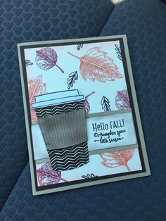 a close up of a card with a coffee cup on the back of a car seat