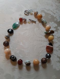 A beautiful assorted gemstone necklace chain linked. Assorted beads are sandstone, carnelian, onyx, jasper, turquoise and other assorted beads. These beautiful beads measure from.12mmm to 18mm.the flat beads measure 35mm by 24mm. A great look for any occasion. Carnelian Jewelry With Colorful Beads For Jewelry Making, Multicolor Beaded Carnelian Jewelry, Multicolor Agate Beaded Necklaces With Oval Beads, Multicolor Agate Beaded Necklaces, Multicolor Carnelian Round Bead Jewelry, Multicolor Round Carnelian Bead Jewelry, Multicolor Carnelian Bead Jewelry, Adjustable Multicolor Agate Necklace, Agate Gemstone Beads Necklaces