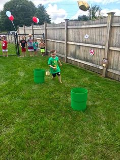 a young boy playing with plastic buckets in the yard