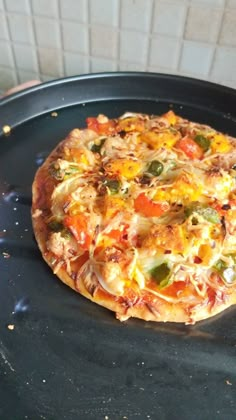 a pizza sitting on top of a pan covered in cheese and veggie toppings