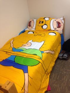 a yellow bed with cartoon characters on it