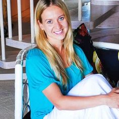 a woman sitting in a chair smiling at the camera