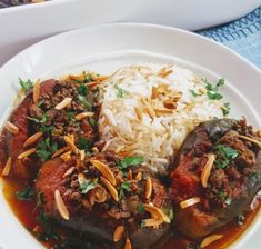 two white plates topped with meat and rice