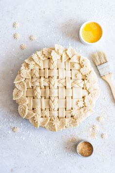 the pie is ready to be baked and decorated with icing next to a bowl of orange juice