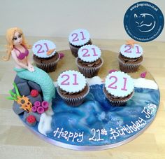 a birthday cake decorated with cupcakes and a mermaid on the top is for 21st birthday