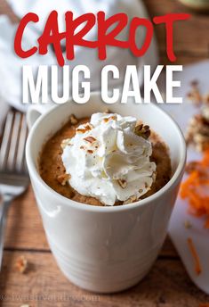 carrot mug cake with whipped cream in a white cup on a wooden table next to a fork