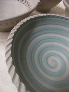 a blue and white bowl sitting on top of a counter next to another bowl in the background