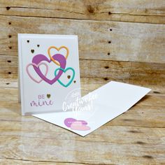 a card with two hearts on it and the words be mine written in different colors