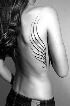 the back of a woman's body is shown with an intricate tattoo on it