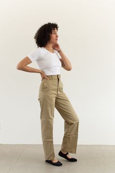 "These military khaki twill wide leg pants are the perfect addition to any wardrobe. They feature the following: zipper fly, straight wide leg, side pockets, back pockets, belt loops. Material: 100% Twill Cotton | Made in the USA in the 60s Condition: Excellent. Deadstock. Unwashed. Measurements: 24\" Waist Button / 34\" Hips / 13\" Rise / 11.5\" Thigh Flat / 31\" Inseam 25\" Waist Metal Tab / 35\" Hips / 13\" Rise / 11.5\" Thigh Flat / 31\" Inseam 26\" Waist Button / 35-36\" Hips / 13\" Rise / Fitted High Waist Wide Leg Khaki Pants, Fitted Full Length Khaki Wide Leg Pants, Khaki High-waisted Wide Leg Cargo Pants, High-waisted Khaki Wide Leg Cargo Pants, Wide-leg Chinos With Belt Loops For Everyday, Wide Leg Chinos With Belt Loops For Everyday, Retro Wide Leg Cargo Pants For Spring, Utility Wide Leg Fitted Work Pants, Solid Cargo Style Work Pants