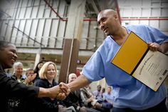 a man in scrubs shaking hands with people