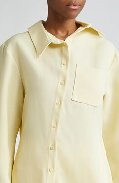 The asymmetric placket of this butter-yellow shirt shifts the collar, J-shaped chest pocket, hem and drape of the back box pleat slightly off-kilter. Asymmetric front-button closure Asymmetric point collar Long sleeves with one-button cuffs Chest patch pocket 88% viscose, 12% polyester Dry clean Imported Designer Clothing Yellow Blouse With Pockets, Yellow Spread Collar Shirt For Work, Elegant Yellow Collared Shirt, Elegant Yellow Collared Blouse, Elegant Collared Yellow Tops, Elegant Yellow Workwear Shirt, Elegant Yellow Collared Tops, Collared Yellow Shirt For Work, Yellow Collared Shirt For Work