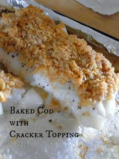 baked food with cracker topping sitting on top of aluminum foil in front of a wooden table