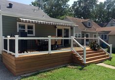 a house with a deck and railing in the front yard