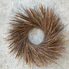 a close up of a dried grass wreath on the ground with no one around it