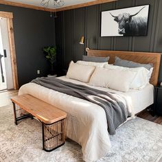 a large bed sitting in a bedroom next to a wooden bench