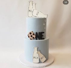 there is a blue cake with milk and cookies on it that reads one mile, milk bottle, polka dot