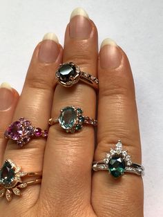 a woman's hand with five different rings on it