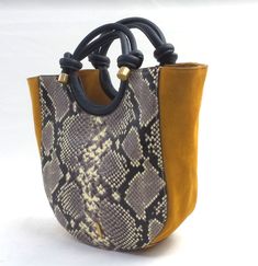 Specifications Style: Claire Snake-embossed cow leather body, double handles, removable shoulder strap, snap closure Lined interior, zip pocket, slip pocket Measures approximately 9"W x 10"H x 4"D with 4.5" handles and a 12" strap drop; weighs 1 lb, 8 oz Body 100% leather; lining 100% polyester Trendy Tan Leather Bags, Trendy Handmade Leather Shoulder Bag, Fall Tan Leather Bag, Tan Leather Bag For Fall, Handmade Leather Bags For Errands, Embossed Leather, Cow Leather, Leather Tote, Bags Handbags