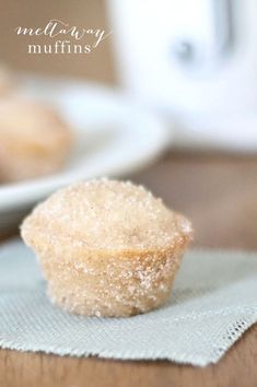 a sugary muffin sitting on top of a napkin next to a cupcake