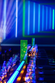 a long table with many wine glasses on it and some lights in the back ground