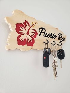 a wooden key holder with two keys hanging from it's side and a sign that says puerto rica