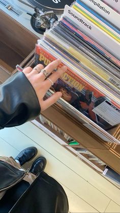 a person's hand reaching for a stack of magazines