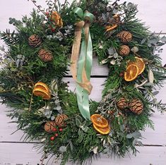 a wreath with oranges and pine cones on it