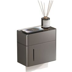 a gray box with a candle and some sticks in it on a white background,