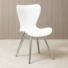 a white chair sitting in front of a wall