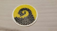 a white plate topped with lots of black and yellow beads