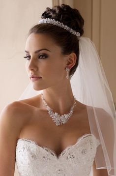 a woman in a wedding dress wearing a bridal necklace and tiara with pearls