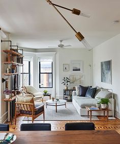 a living room filled with furniture and a wooden table in front of a large window