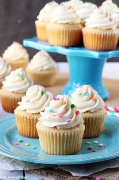 cupcakes with white frosting and sprinkles on a blue plate