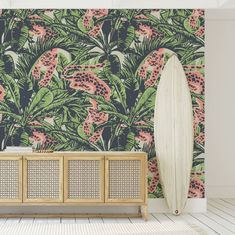 a white surfboard sitting on top of a wooden cabinet in front of a wall