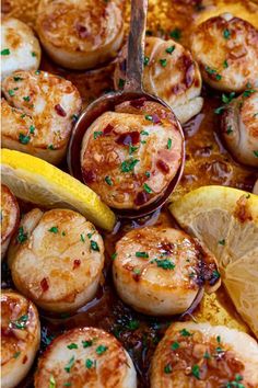 a pan filled with cooked scallops and lemon wedges