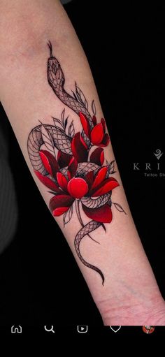 a woman's arm with a red flower and snake tattoo on the left forearm