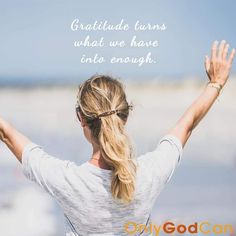 a woman standing on the beach with her arms up and hands raised in the air