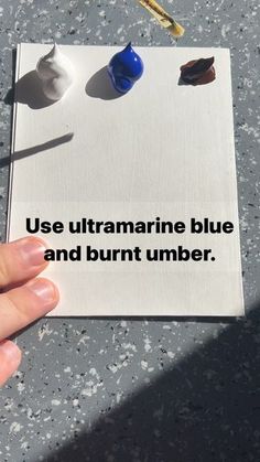 a person holding up a piece of paper with writing on it that says use ultramarine blue and burnt number