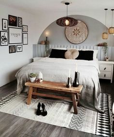 a bed room with a neatly made bed and lots of pictures on the wall above it