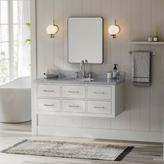 a white bathroom with two sinks and mirrors