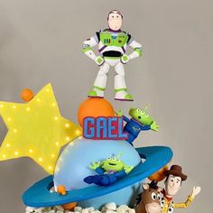 a birthday cake with toy characters on top and the words gael spelled in large letters