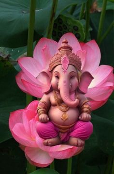 an elephant statue sitting on top of a pink flower