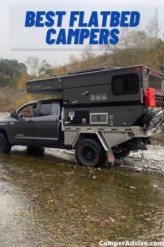 a truck with a camper attached to it driving through water