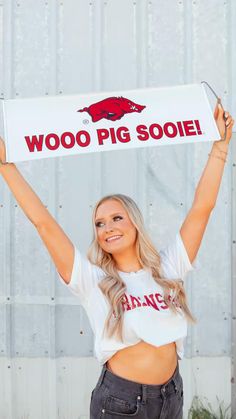 a woman holding up a sign with the word woo pig sooe written on it