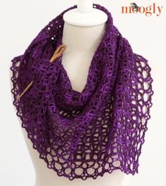 a purple crocheted scarf on top of a white mannequin headdress