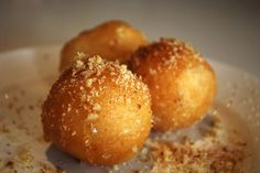 two donuts with sugar sprinkled on them in a white bowl