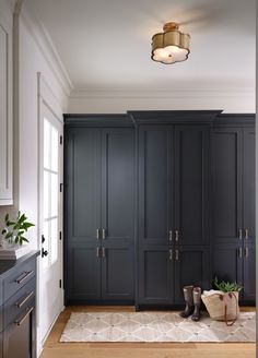 an empty room with black cabinets and wooden flooring in the center, along with a rug on the floor