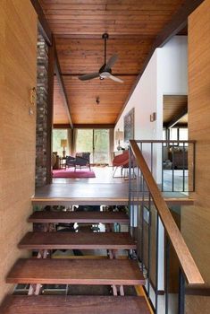 the inside of a house with wood floors and stairs leading up to an open floor plan